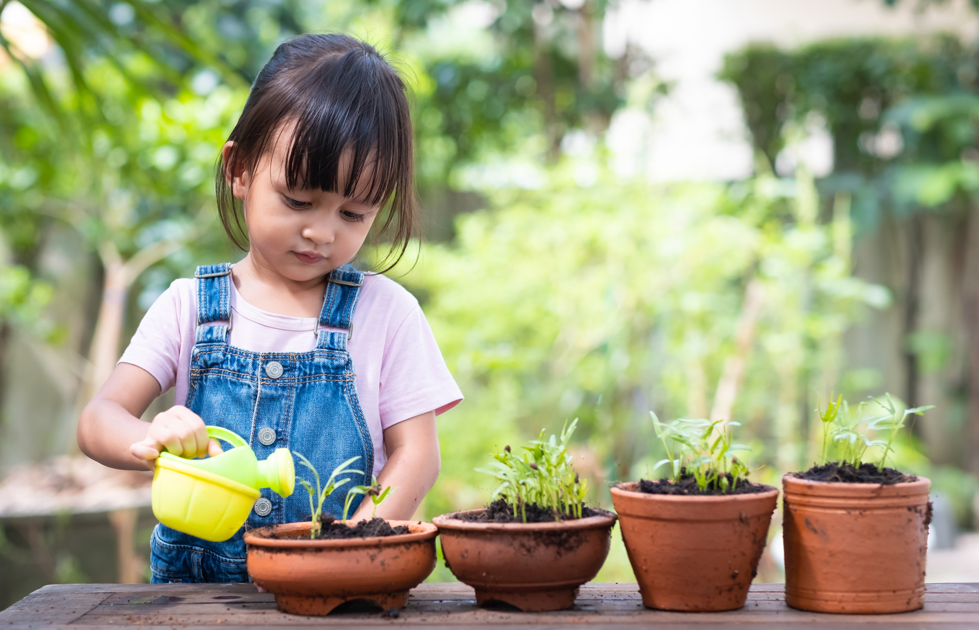 girl watering plants in garden